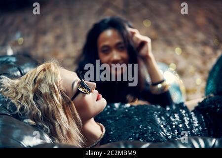 Pretty young woman relax and lying on sofa after crazy party Stock Photo