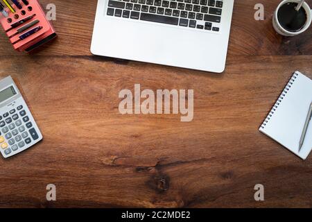 Laptop on Vintage Wooden desktop in modern office with accessories - top view on desk from above. Stock Photo