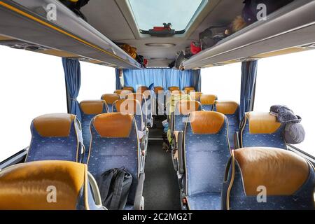 Bus interior empty seats, stop on a long distance trip, blanked out windows with copy space Stock Photo