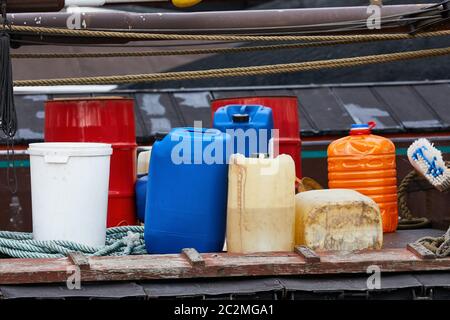 Various plastic cans with chemicals and fuel in a ship harbor Stock Photo