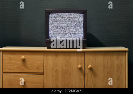 Small old TV set with no signal noise in a dim room Stock Photo
