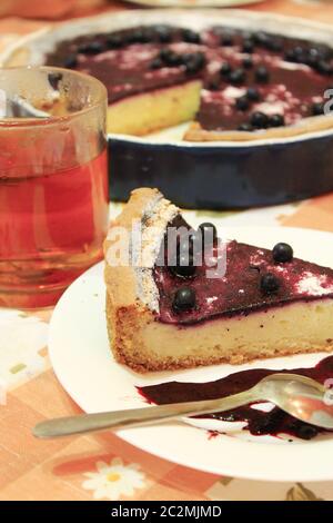 Piece of pie with bilberry on the plate and cup of tea Stock Photo