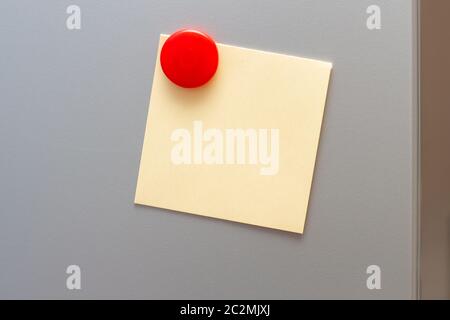Yellow empty notes attached red magnet on fridge Stock Photo