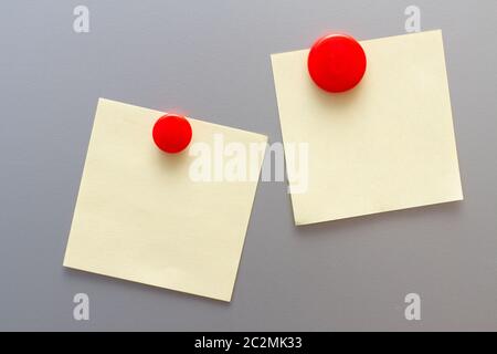 Yellow empty stickers attached red magnet on fridge Stock Photo