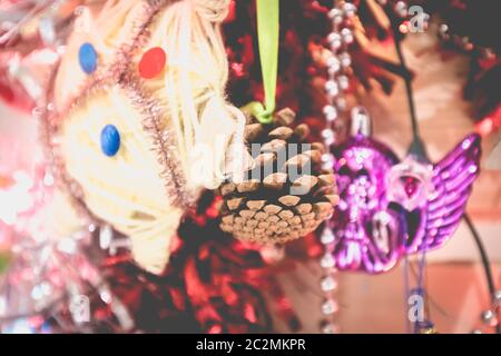 Christmas decoration made by children garlands, balls and pine cone on a fir tree made from wooden board at home Stock Photo