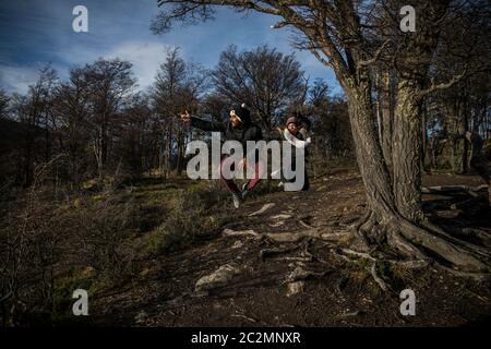 couple jumping i the forest with beautiful landscape Stock Photo