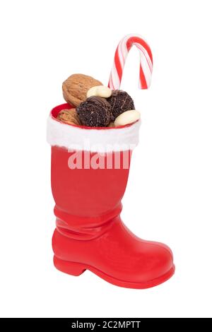 Christmas decorations isolated. Close-up of a red Santa Claus boots filled with nuts and other sweets isolated on a white background. Macro photograph Stock Photo