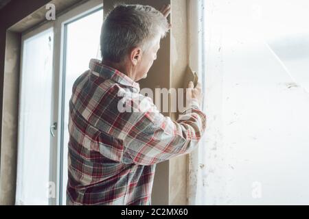 Diligent plasterer working on a window opening Stock Photo