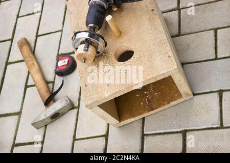 Drilling holes in the birdhouse Stock Photo