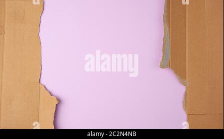 torn edges of corrugated cardboard paper with purple background, abstract backdrop template Stock Photo