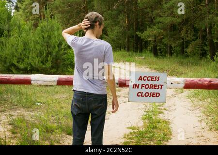 Man stands in front of a barrier in the forest Stock Photo