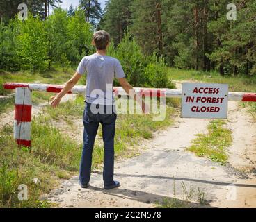 Man stands in front of a placard prohibiting Stock Photo