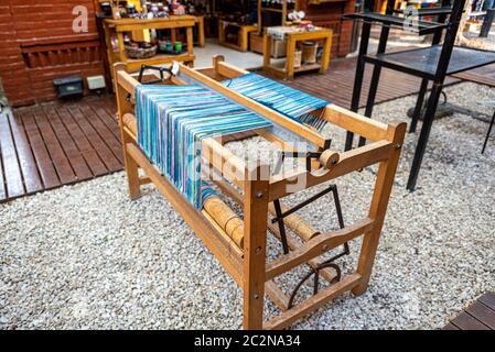 Old wooden loom with light blue threads of wool Stock Photo