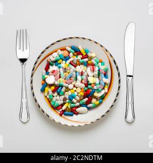 Medical dinner set with silverware and pills Stock Photo