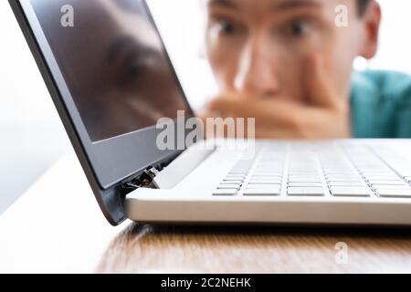 Man Looking At Damaged Laptop Computer With Broken Screen Attachment Stock Photo