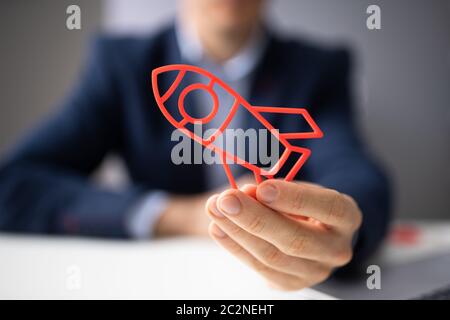 Close-up Of A Businessperson's Hand Flying Rocket Stock Photo