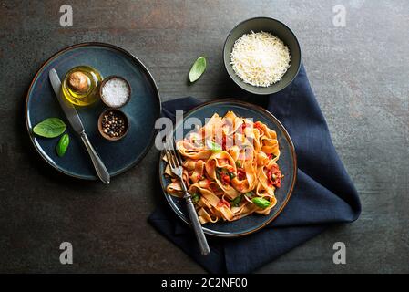 Tasty appetizing classic italian pasta with tomato sauce, cheese parmesan and basil on plate. View from above Stock Photo