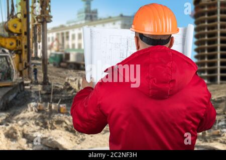 Contractor reading plans against construction site Stock Photo