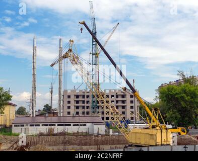 Tower cranes against blue sky, with clouds Stock Photo