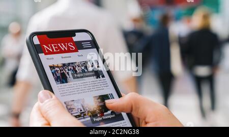 Online news on a mobile phone. Close up of businesswoman reading news or articles in a smartphone screen application. Hand holding smart device. Mockup website. Newspaper and portal on internet. Stock Photo