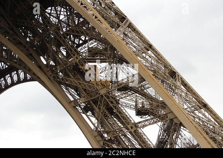 An Eiffel Tower detail view with the West Pillar Lift in cloudy day, Paris, France Stock Photo