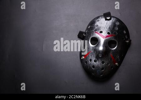 Hockey mask of serial killer with bloody strips isolated on black background. Murder horror Stock Photo