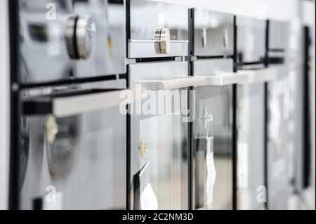 Brand new electric ovens at appliance store Stock Photo