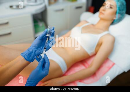 Cosmetician makes botox therapy to female patient on treatment table. Rejuvenation procedure in beautician salon. Doctor and woman, cosmetic surgery a Stock Photo