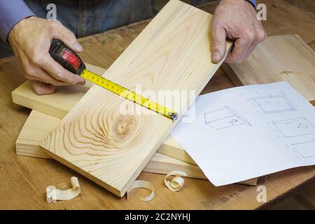 Carpenter makes a birdhouse in the workshop by sketch Stock Photo