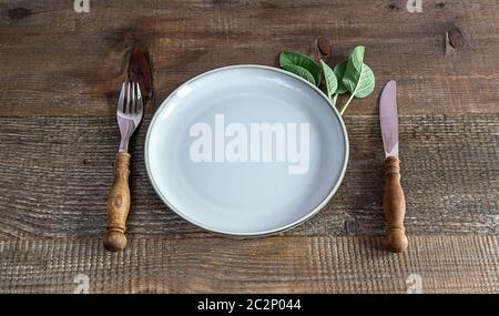 Rustic style. Table setting with cutlery and empty plate on old wood.  Stock Photo