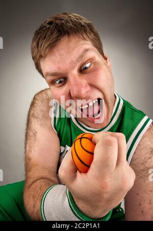 Portrait of bizarre basketball player with small ball Stock Photo