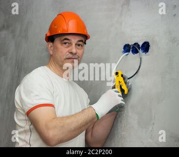 Electrician busy repairing wiring in apartment Stock Photo