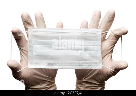 Doctor holding surgery medical face mask in hands in gloves isolated on white background. Medicinal concept protective clothing, equipment Stock Photo