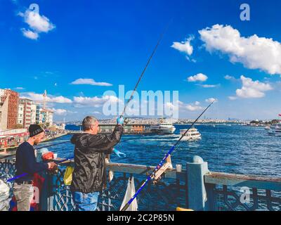 October 27, 2019 Istanbul. Turkey. Fisherman fishing on the Galata Bridge in Istanbul Turkey. People walk on Galata bridge. Vaca Stock Photo