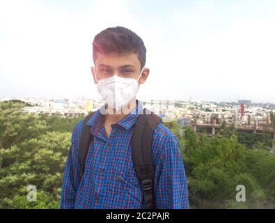 portrait of handsome teen student wearing face mask . teen with backpacks. Stock Photo
