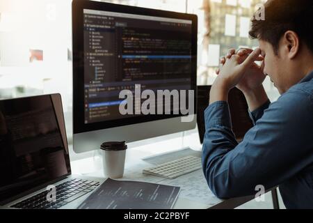 Software developers headache with code analysis in the office. Stock Photo