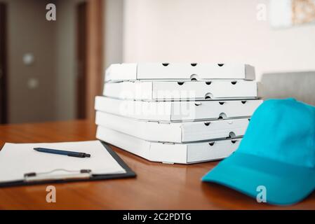 Carton pizza boxes, cap and empty order on table, top view. Pizza delivery business concept, fast delivering service, nobody Stock Photo