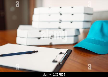 Carton pizza boxes, cap and empty order on table, top view. Pizza delivery business concept, fast delivering service Stock Photo