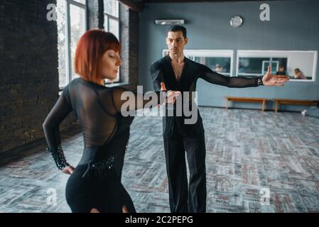 Dancers in costumes on ballrom dance training in class. Female and male partners on professional pair dancing in studio Stock Photo