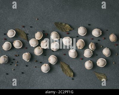 Beautiful scattered raw pelmeni on marble background Stock Photo