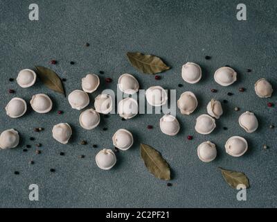 Beautiful scattered raw pelmeni on marble background Stock Photo