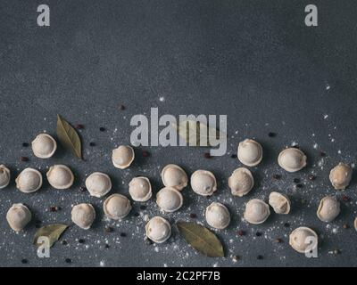 Beautiful scattered raw pelmeni on marble background Stock Photo