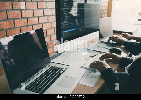 Two partnerships developing programming and coding technologies working on laptop and analyzing together. Stock Photo