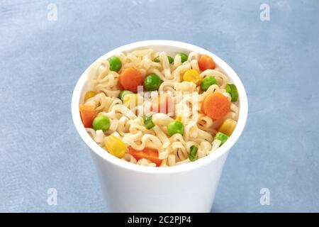 Ramen cup close-up, instant soba noodles in a plastic cup with vegetables Stock Photo