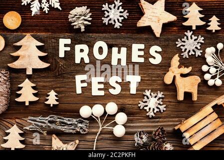 Letters Building The Word Frohes Fest Means Merry Christmas. Wooden Christmas Decoration Like Tree, Sled And Star. Brown Wooden Background Stock Photo