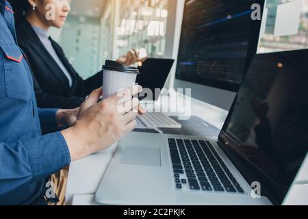 Working in the morning with businessmen are dipping coffee that works with software developers to analysis together the code written in the program on Stock Photo