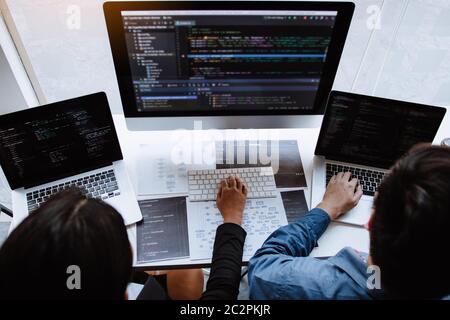 Professional development programmer cooperating meeting programming website working a software in office room. Stock Photo