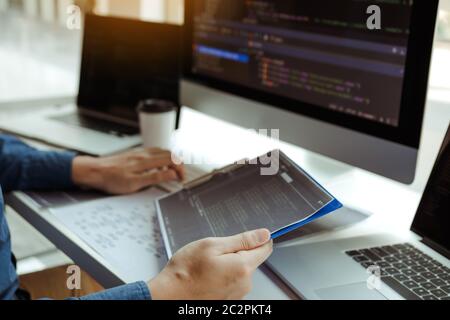 Asian man working code program developer computer web development working design software on desk in office. Stock Photo