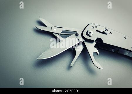 Black opened multitool knife closeup. Toned Stock Photo