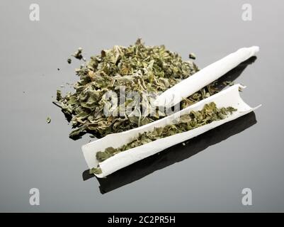 Handmade cigarette with dried marijuana on gray background Stock Photo